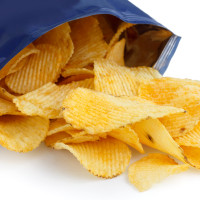 Crinkle cut crisps spilling out of a foil packet.